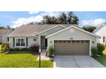 Charming single-story home with a well-maintained lawn, attached two-car garage and mature landscaping at 25406 Crestwater Dr, Leesburg, FL 34748
