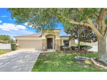 Charming single-story home with a well-manicured lawn, mature tree and inviting front entrance at 2889 Columbus Ave, Clermont, FL 34715
