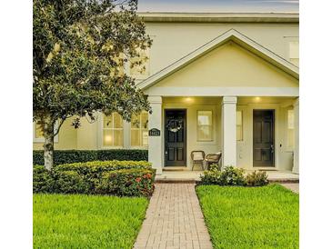 Inviting front entrance featuring a brick walkway, manicured lawn, and cozy seating area at 14421 Vashons Way, Winter Garden, FL 34787