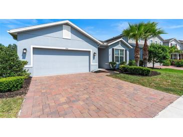 Charming home with brick driveway, well-maintained lawn, and manicured shrubs at 17112 Goldcrest Loop, Clermont, FL 34714