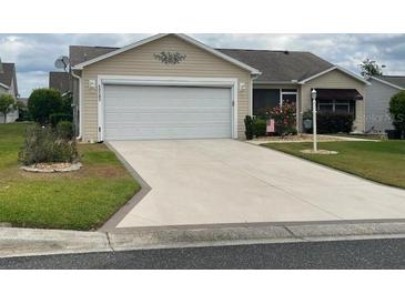 Charming single-story home featuring a spacious driveway, two-car garage, and well-maintained landscaping at 1723 Banberry Run, The Villages, FL 32162