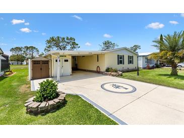 Charming single-story home with a well-manicured lawn and decorative palm tree design on the driveway at 1726 W Schwartz Blvd, Lady Lake, FL 32159