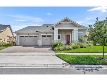 Charming single-story home featuring a three-car garage, well-manicured lawn, and inviting entryway at 2666 Meadowedge Loop, St Cloud, FL 34772