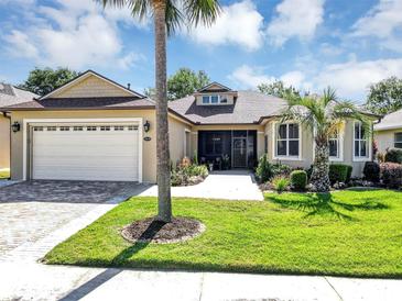 Charming home featuring a two-car garage, manicured lawn, and mature palm trees at 3519 Arlington Ridge Blvd, Leesburg, FL 34748