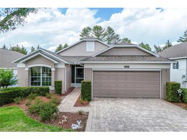 Charming single-story home with a well-manicured lawn, paver driveway, and a two-car garage at 4083 Capland Ave, Clermont, FL 34711