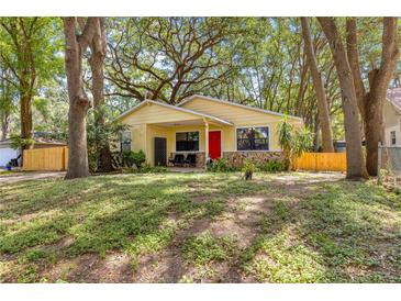 Charming bungalow with a bright red door and stone accents, nestled among mature trees at 43 Almond Pass Dr, Ocala, FL 34472