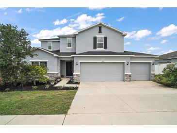 Charming two-story home with a three car garage, manicured landscaping, and a welcoming front entrance at 605 Black Eagle Dr, Groveland, FL 34736