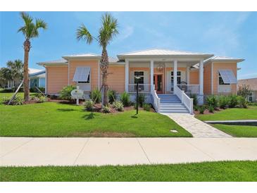 Charming peach-colored home with a welcoming front porch and beautifully landscaped yard at 1127 Fiesta Key Cir, Lady Lake, FL 32159