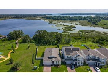Beautiful aerial view of homes near a lake and boardwalk trails on a sunny day at 124 Juno Dr, Groveland, FL 34736