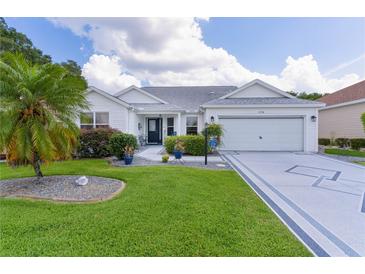 Charming single-story home with a well-manicured lawn, a decorative driveway, and a two-car garage at 2738 Morven Park Way, The Villages, FL 32162