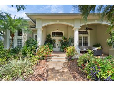 Welcoming front entrance with lush landscaping, white pillars, and comfortable outdoor seating area at 2904 Avalos Dr, The Villages, FL 32162
