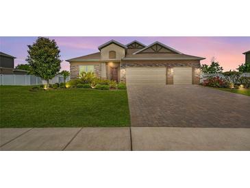 Charming single-Gathering home showcasing a well-manicured lawn and brick driveway at sunset at 3222 San Leo Dr, Orlando, FL 32820