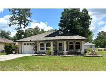 Charming single-story home with well-manicured lawn and inviting front porch at 5051 Nw 61St Ct, Ocala, FL 34482