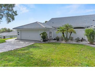 A lovely home featuring a pristine two-car garage, a brick driveway, and well-manicured landscaping at 6048 Topsail Rd, Lady Lake, FL 32159