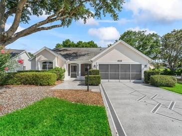 Charming single-story home with a well-manicured lawn, decorative driveway, and inviting facade at 628 San Pedro Dr, The Villages, FL 32159