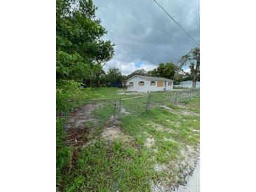 Modest single-story home with boarded windows on a lot needing some TLC at 11626 Fairmont Ave, Leesburg, FL 34788