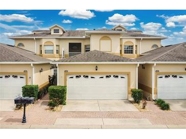 Charming townhome featuring a well-manicured lawn and a two-car garage, all under a bright blue sky at 17406 Chateau Pine Way, Clermont, FL 34711