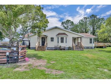 A charming home with a large backyard and mature trees provides a serene outdoor living space at 21320 Paradise Way, Eustis, FL 32736