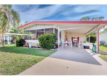 Charming single-story home with a welcoming screened-in porch and covered carport with picket fence at 2475 Karen Dr, Mount Dora, FL 32757