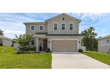 Charming two-story home featuring a spacious two-car garage and a well-maintained lawn at 2532 Autumn Stream Dr, Leesburg, FL 34748