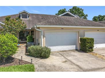 Charming townhome with attached garage, tidy landscaping, and a welcoming facade at 264 Juniper Way, Tavares, FL 32778