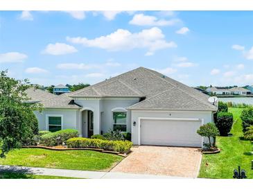 Charming single-story home featuring a brick driveway and manicured landscaping at 313 Blue Cypress Dr, Groveland, FL 34736