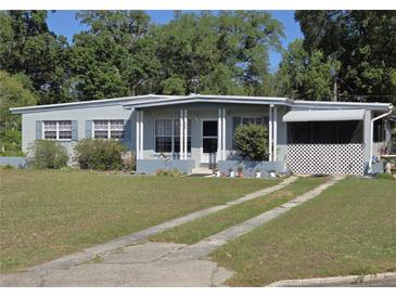 Charming single-story home featuring a well-maintained lawn, covered porch, and a welcoming facade at 504 Se 35Th Ave, Ocala, FL 34471