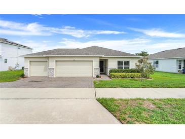 Charming single-story home with a three car garage, well-maintained landscaping, and a brick driveway at 641 Black Eagle Dr, Groveland, FL 34736