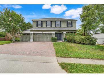 Charming two-story home with a three-car garage and beautiful landscaping, brick driveway, and a well-maintained lawn at 107 Wekiva Pointe Cir, Apopka, FL 32712