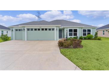 Charming one-story home featuring a two-car garage and well-maintained landscaping at 1449 Jeremy Cir, The Villages, FL 34762