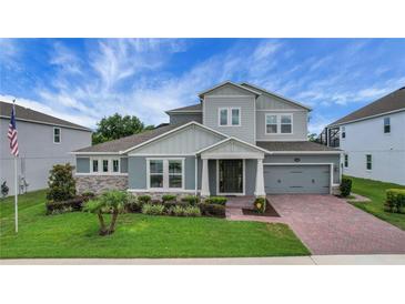 Stunning two-story home featuring a brick driveway, a two-car garage, and a beautifully landscaped yard at 14501 Wabasso Loop, Winter Garden, FL 34787
