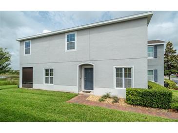 Charming two-story home with a well-maintained lawn and inviting front entrance at 212 Primrose Dr, Davenport, FL 33837