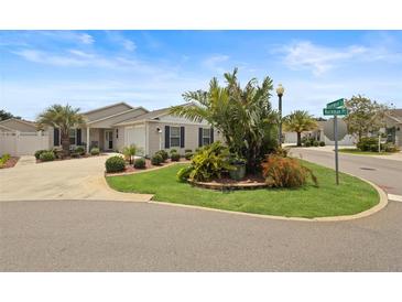 Charming single-story home featuring a well-manicured lawn and lush landscaping at 2312 Nackman Pl, The Villages, FL 32162