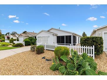 Charming home featuring a white picket fence, well-kept landscaping, and a welcoming exterior at 2317 Whisper St, The Villages, FL 32162