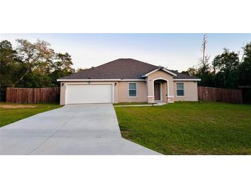 Charming one-story home with a spacious front yard, long driveway, and a two-car garage at 4002 Sw 158Th Street Rd, Ocala, FL 34473
