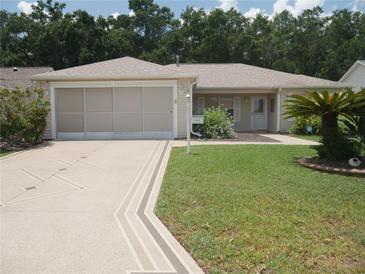 Charming single-story home boasts a well-manicured lawn and decorative driveway, enhancing its curb appeal at 8377 Se 177Th Bartram Loop, The Villages, FL 32162