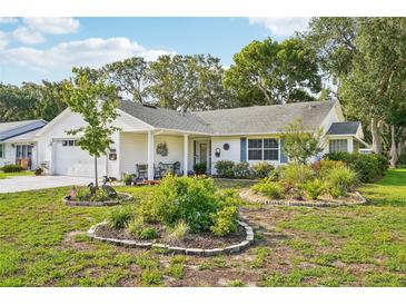 Charming single-story home featuring a well-manicured lawn, lovely landscaping, and inviting curb appeal at 1214 Loch Rannoch Ct, Leesburg, FL 34788