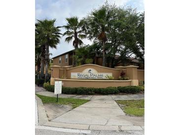 Regal Palms at Highland's Reserve entrance featuring lush landscaping and elegant signage with palm tree accents at 130 Napoli Dr, Davenport, FL 33897