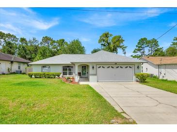 Charming single-story home with well-maintained lawn and attached two-car garage at 39 Pine Court Dr, Ocala, FL 34472