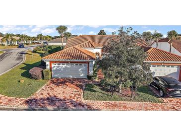 Charming single-story home with a red brick driveway, tile roof, and well-manicured landscaping at 5046 Harbour Dr, Oxford, FL 34484