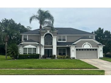 Stately two-story home with manicured lawn and mature landscaping at 633 Grand Cypress Pt, Sanford, FL 32771
