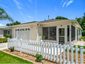 Charming home with a white picket fence, attached garage, and screened-in porch at 8195 Se 174Th Rowland St, The Villages, FL 32162