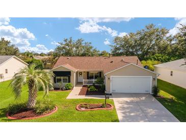 Charming single-story home with a well-manicured lawn, mature trees, and inviting curb appeal at 8537 Se 177Th Bartram Loop, The Villages, FL 32162