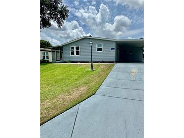 Charming single-story home with a well-maintained lawn and a convenient carport at 1626 Cypress Pt, Lady Lake, FL 32159