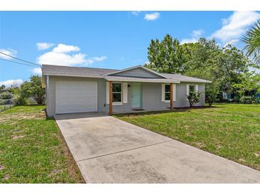 Charming single-story home with a light gray exterior, a well-maintained lawn, and a paved driveway at 4 Kristin Ln, Eustis, FL 32726