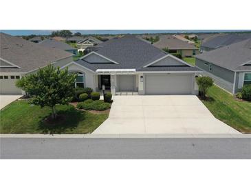 Beautiful single-story home with manicured landscaping and a spacious driveway at 6301 Danielson Loop, The Villages, FL 32163