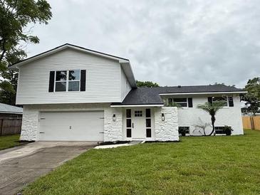 Inviting two-story home with a manicured lawn and a white exterior at 8203 Bluestar Cir, Orlando, FL 32819