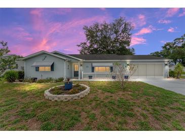 Charming single-story home featuring a well-maintained lawn and an attached two-car garage at 9499 Se 174Th Loop, Summerfield, FL 34491