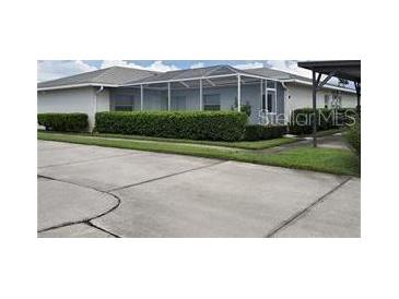 Well-maintained home with a screened-in lanai and manicured hedge landscaping at 1108 Apple Ter, Leesburg, FL 34748