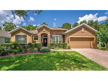 Charming single-story home with manicured lawn, stone accents, and inviting curb appeal at 1556 Blue Grass Blvd, Deland, FL 32724